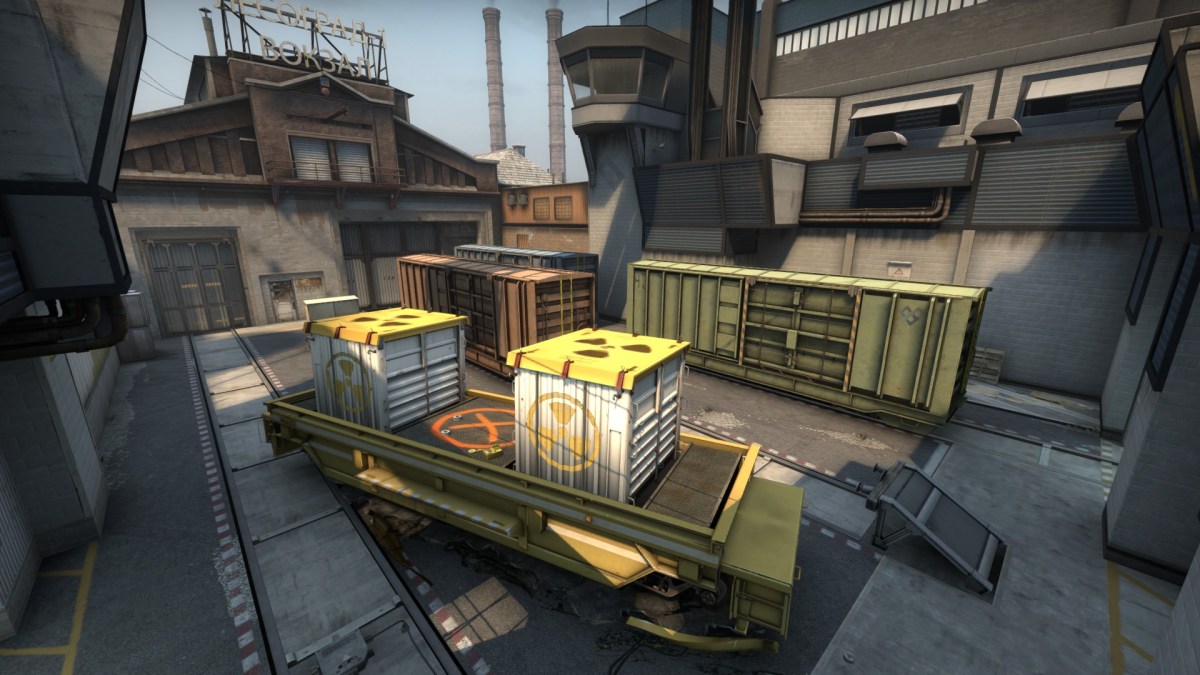 The A bombsite on Train in CS:GO with an assortment of train carriages in a yard.