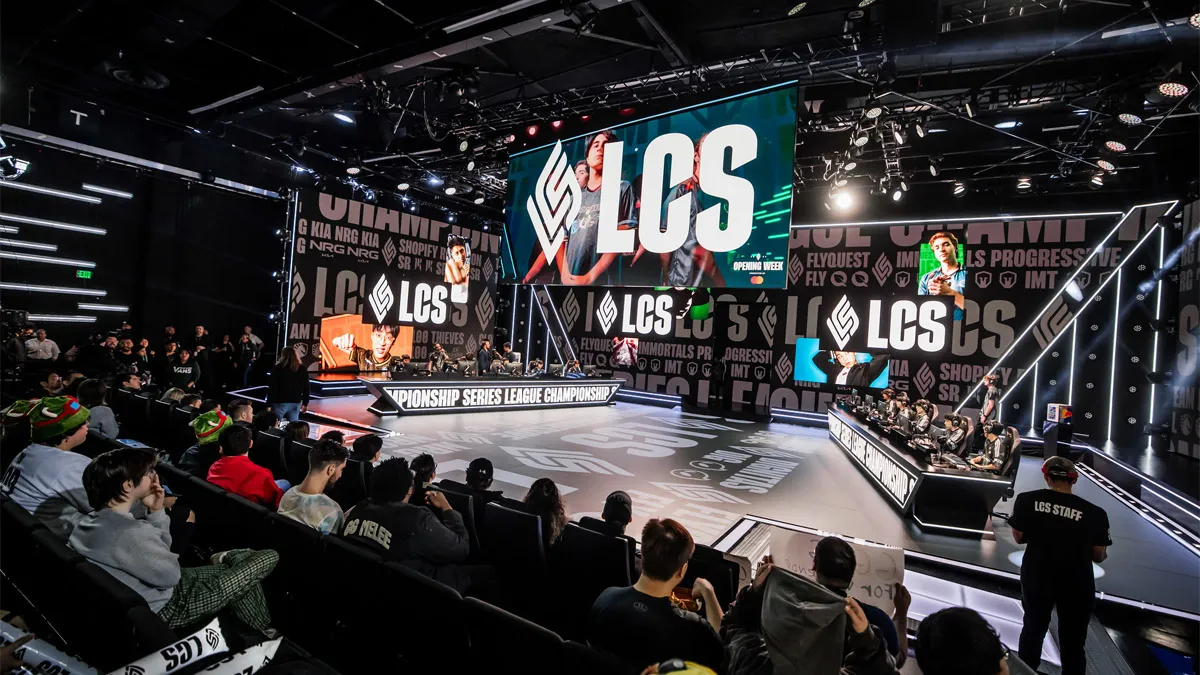 The LCS 2024 stage with League of Legends players playing as fans cheer from their seats.