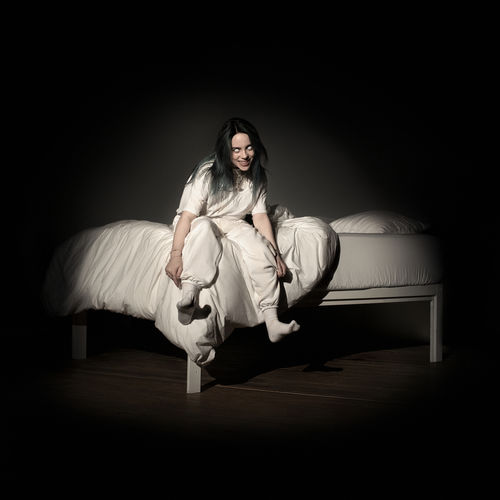 An image of the cover art to the Billie Eilish album titled, When We All Fall Asleep Where Do We Go. This Album has several songs in Fortnite festival ,and features the artist sitting on a white bed. 