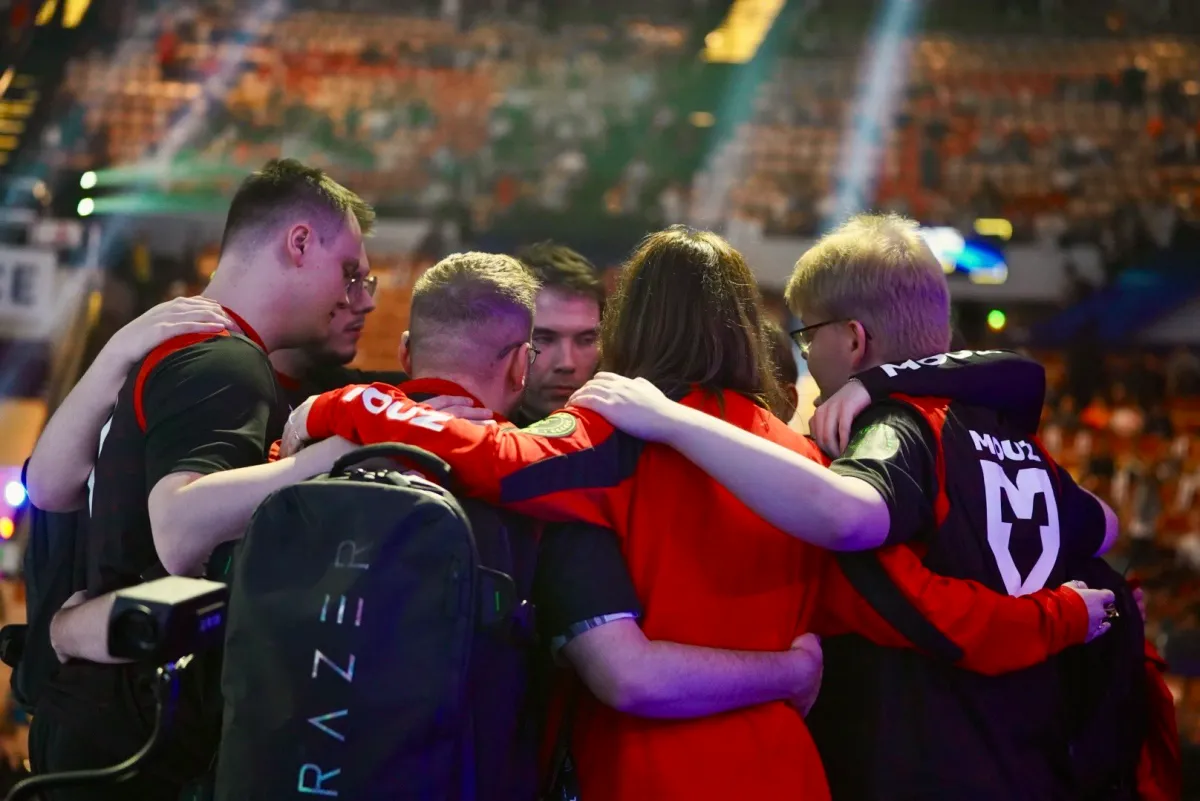 MOUZ players huddle on stage before their semifinal against Faze begins