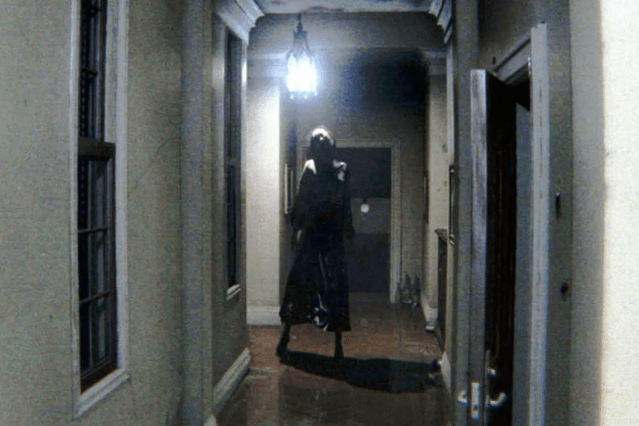 A scary ghost appears at the end of a dimly lit hallway in P.T.