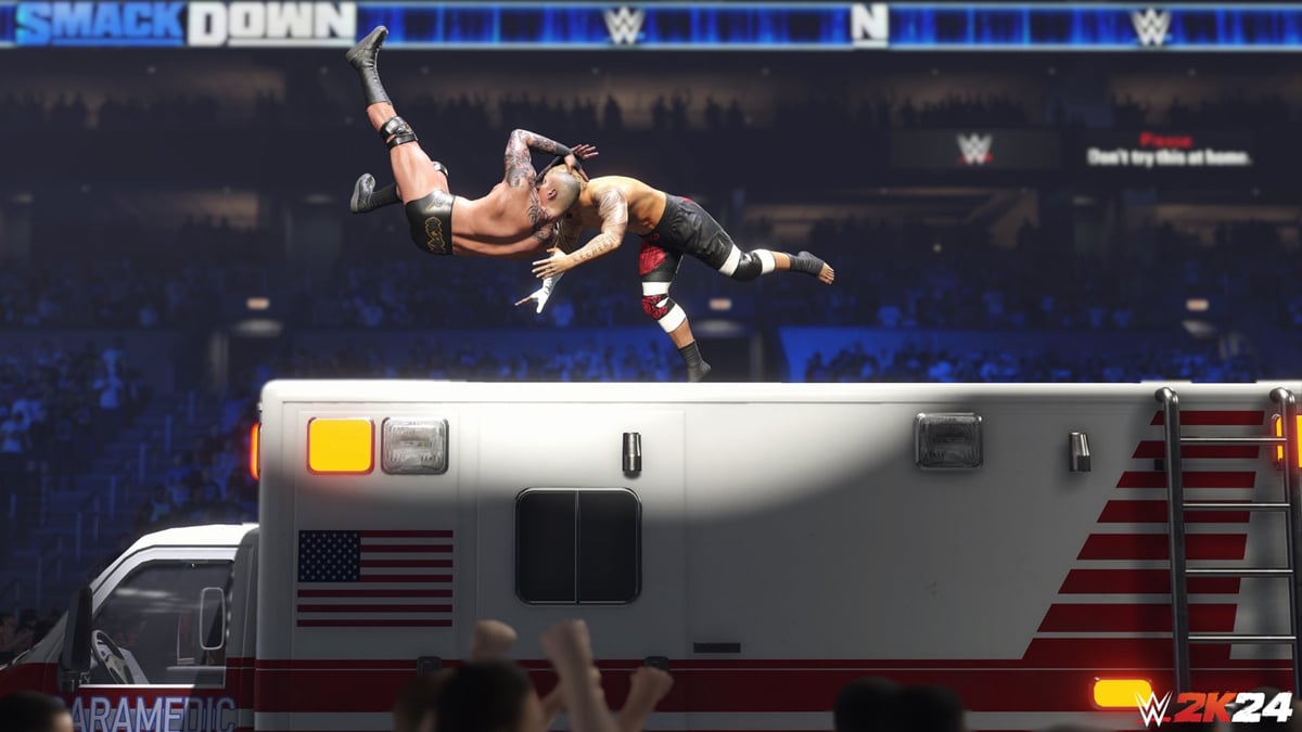 Two wrestlers fight atop an ambulance in a promotional image for WWE 2K24.