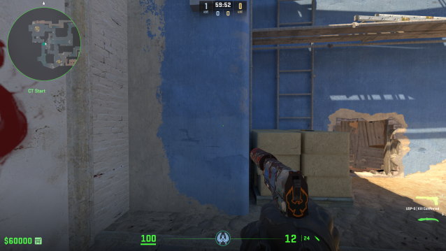 A player holds a pistol staring at a blue wall on Mirage in CS2.