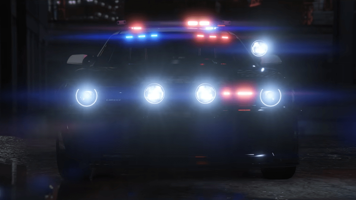 The front of a police car with it's headlights on and lights flashing