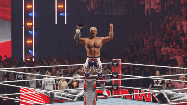 Cody Rhodes standing on the turnbuckle on Raw, holding his arms up in celebration with the World Heavyweight Championship in his right hand.
