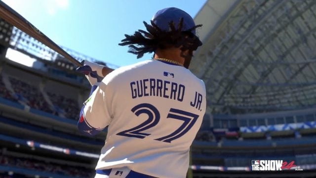 Guerrero Jr hitting the ball, with his back to the camera, inside a stadium.
