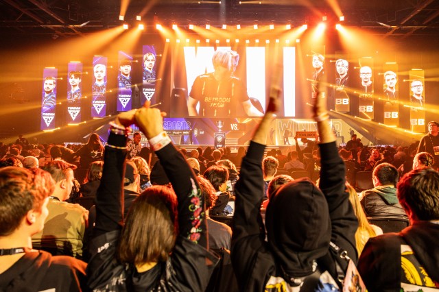 ten Dota 2 players from Tundra and BetBoom take the stage at the esl one Birmingham tournament, with a crowd of fans celebrating.