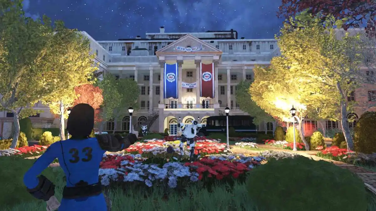 Image of a player character standing with their thumbs up in the Vault Boy pose at night in front of the Whitespring Resort in Fallout 76. There are many flowers around along with banners hanging from the resorts and robots moving around.