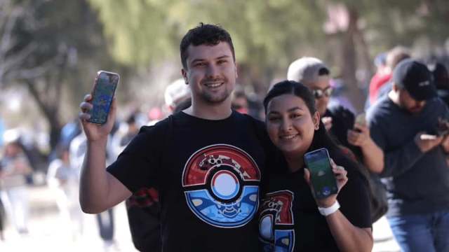 Pokemon Go players at an event holding up their phones.