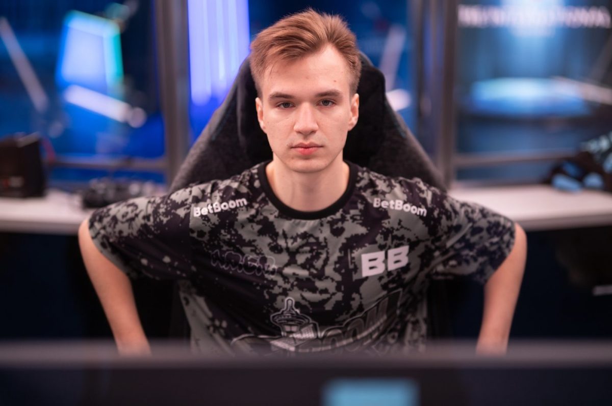 Pure stares ahead at a computer screen sitting just in front of the camera. He is wearing a Dota 2 BetBoom jersey