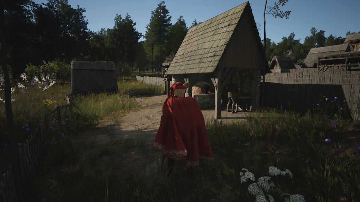 A man in a cloak stands outside an old brewery.