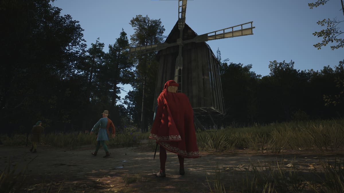 A character in a cloak stands outside a windmill