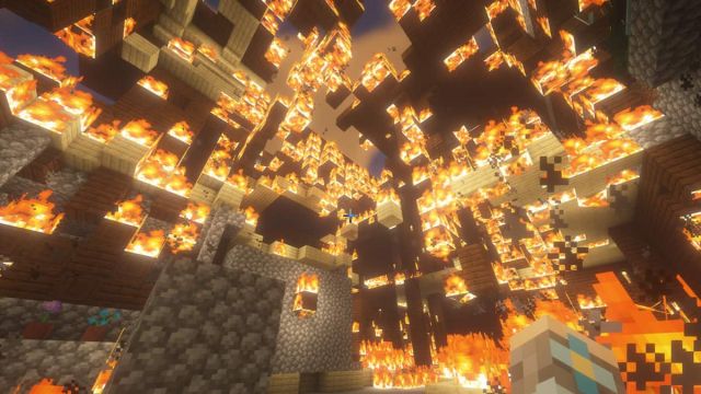 A burning Woodland Mansion in Minecraft.