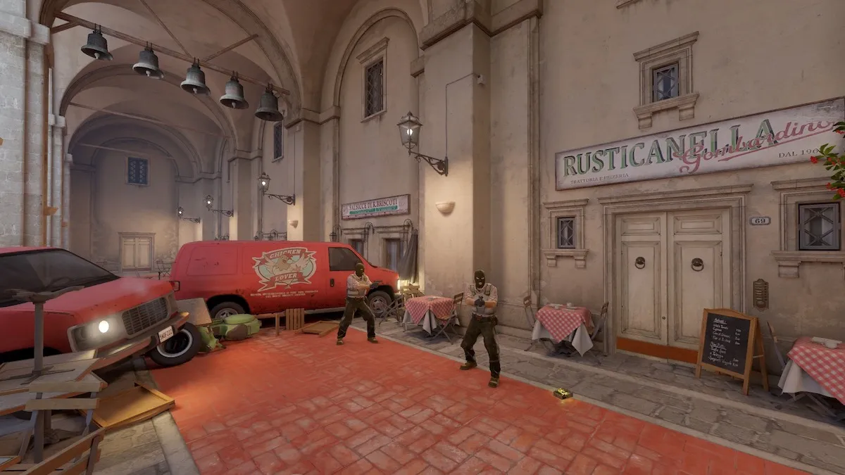 Screenshot taken of Inferno's T Spawn in CS2, featuring two Terrorists holding pistols and the bomb on the ground.