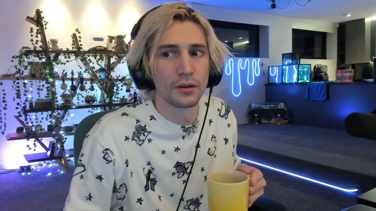xQc holding a yellow mug and looking at the camera sideways