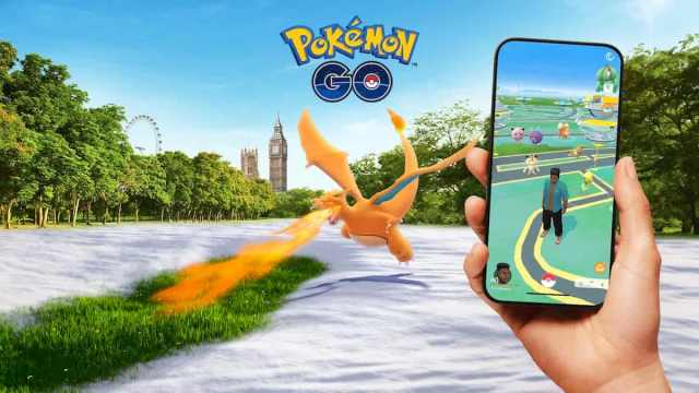 A Charizard breathing fire while a player play Pokemon Go.