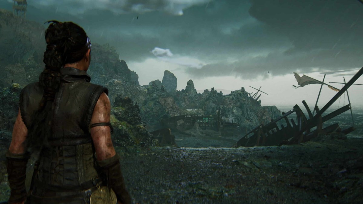 Senua looks at several shipwrecked vessels on a beach