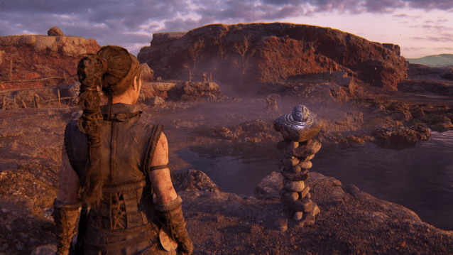 Senua looks at a sphere in a  pedestal puzzle