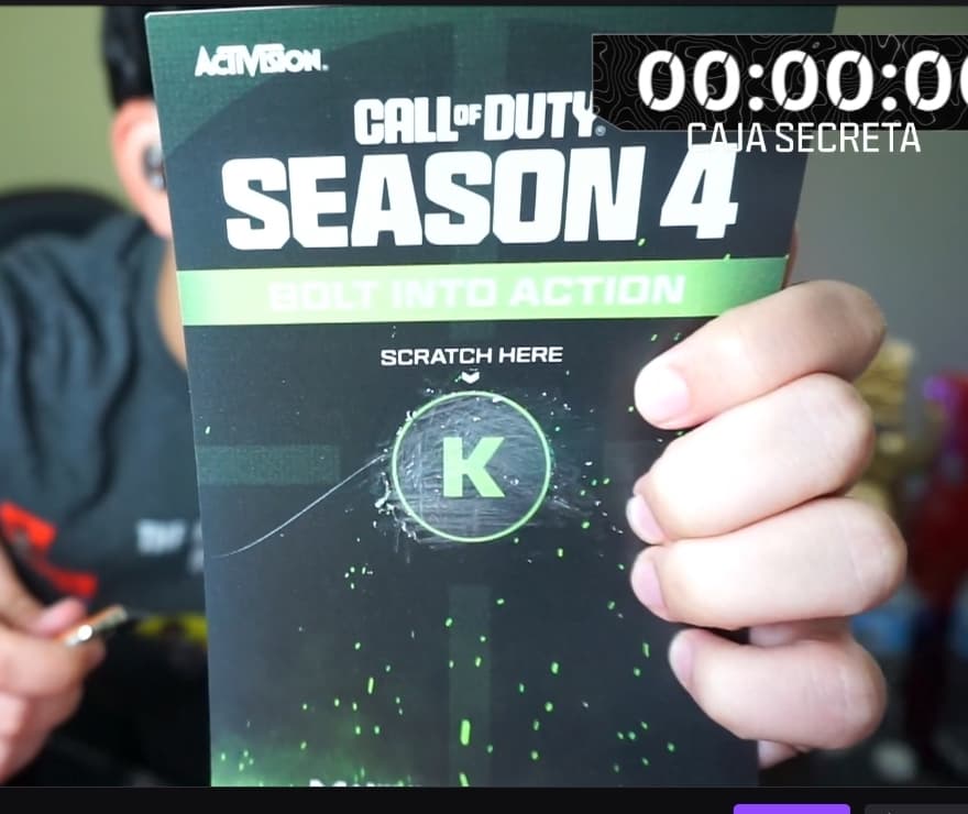 Kestico holds up a promotional card for MW3 season 4 with a "K" in the middle.
