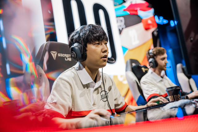 Ssumday sits at his PC while playing League of Legends on-stage.