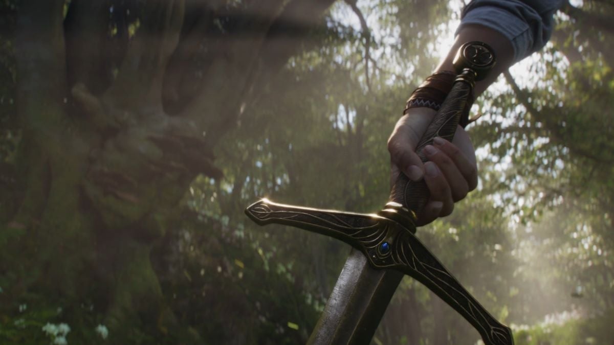 A screenshot of a hand grabbing a sword in a forest from the Fable trailer.