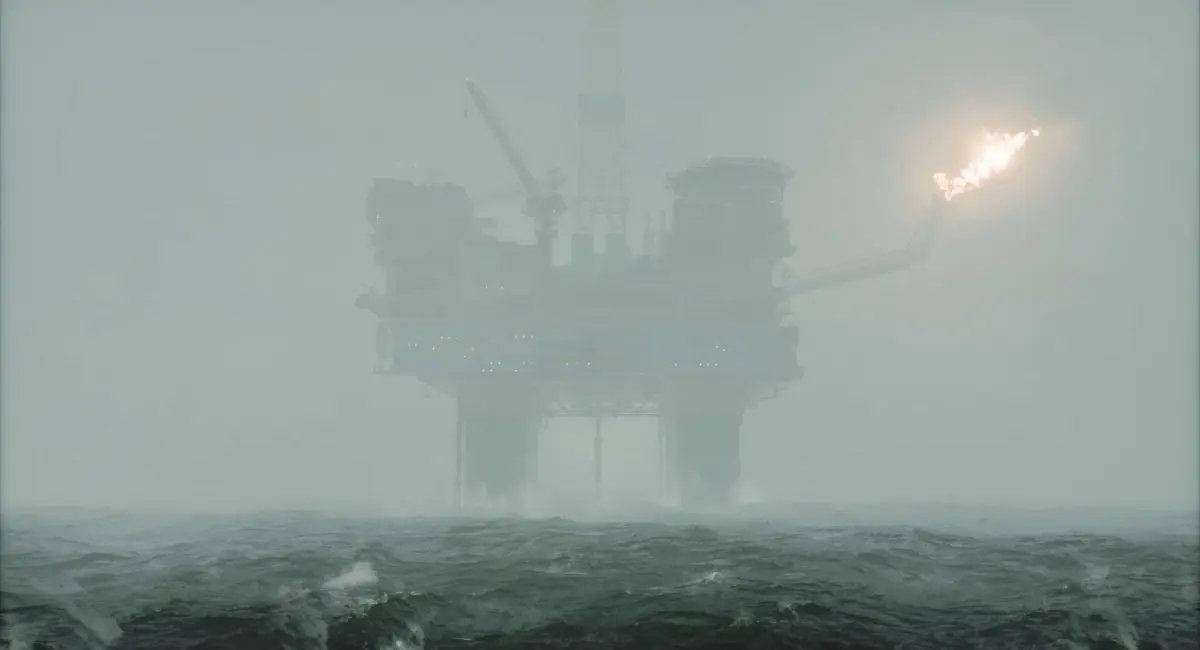 An oil rig can be seen through a layer of fog in the sea