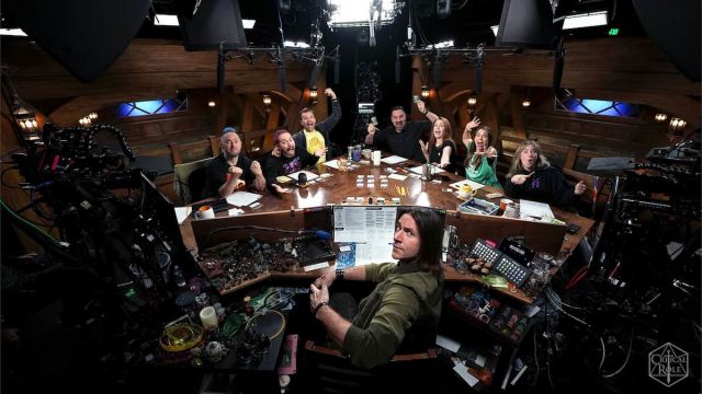 The Critical Role team all siting at the table and looking at the camera.