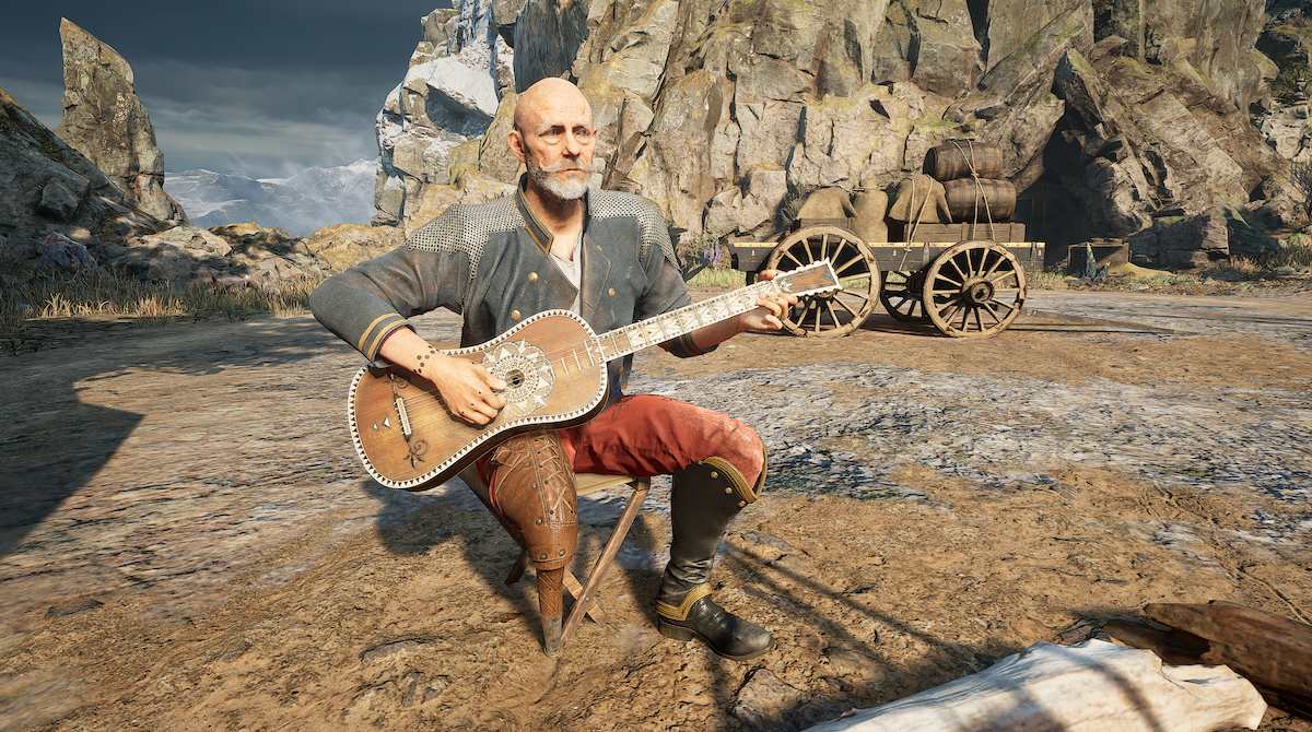 An elderly, bald-headed man sits in front of a wooden cart holding a guitar