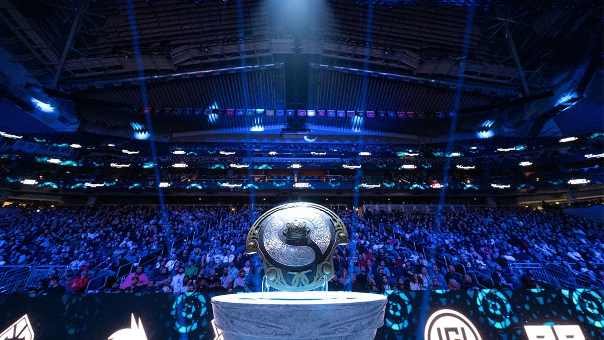 The Aegis of Champions sits on a plinth and lit by a spotlight in the Climate Pledge Arena during TI 2023.