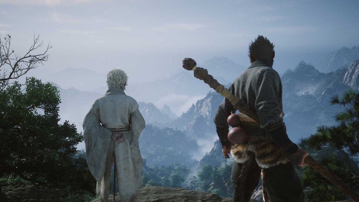 A monkey-like character with a staff stands next to an elder on top of a hill overlooking a mountain enshrouded in fog in Black Myth Wukong.