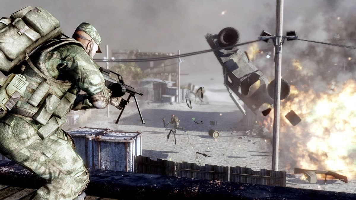 Player character aiming a gun at enemies whilst a car explodes in the background in Battlefield Bad Company 2