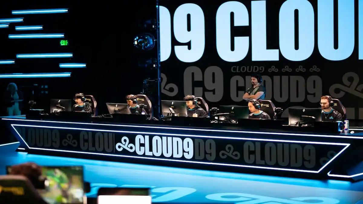 Cloud9's League of Legends roster sitting in a horizontal line on stage in the LCS arena.