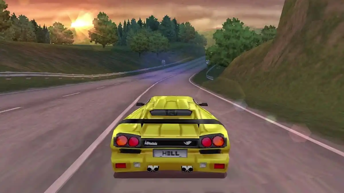 Yellow sports car driving through a mountainous road with the sun setting in the background