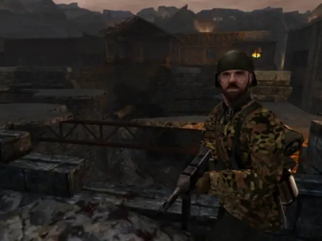 A soldier looking right at the camera with destroyed buildings in the background