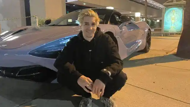 An image of xQc posing with the McClaren he bought with Adept, which she later took.