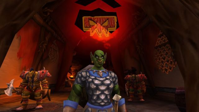 Orc Shaman casting a spell in World of Warcraft with cave background and guards.