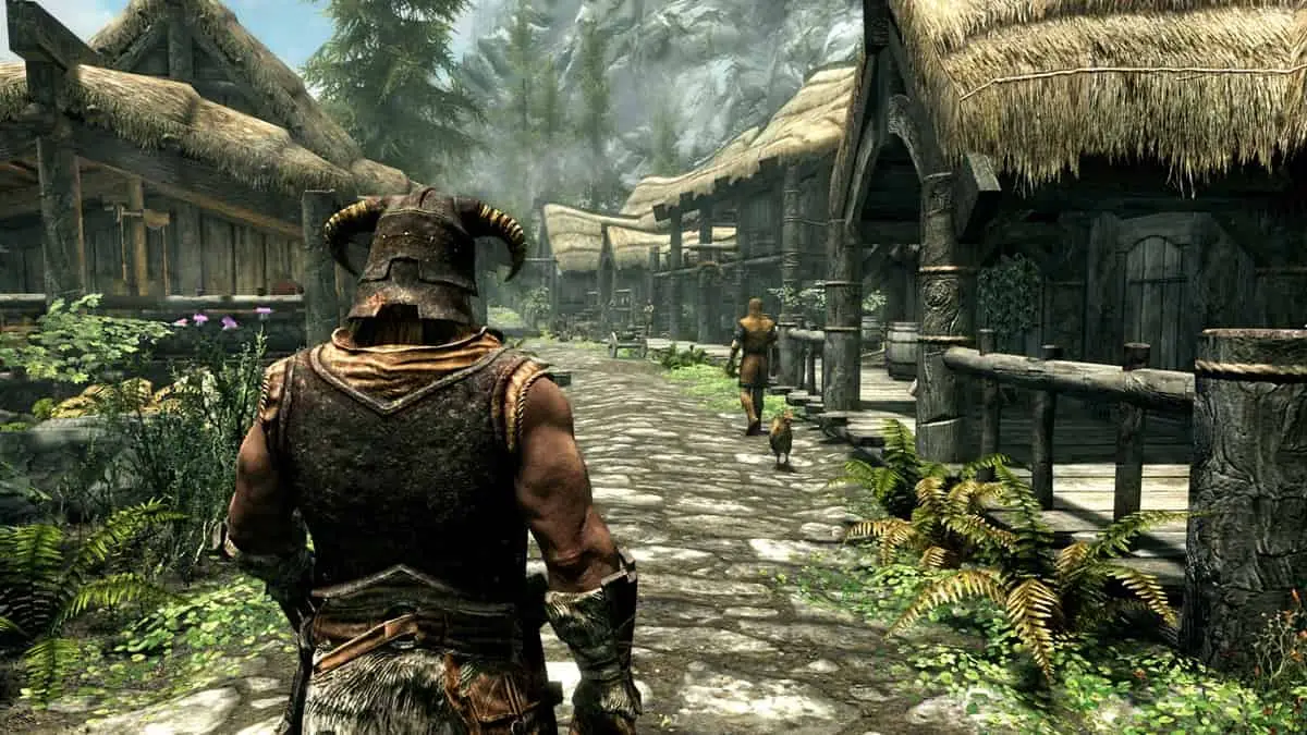 Player character with a horned helmet walking through a village with houses and trees in the background