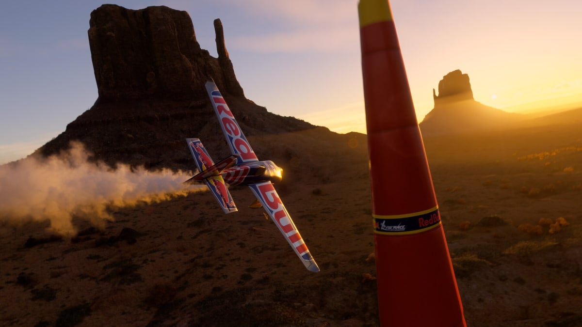 A Red Bull plane in Flight Simulator 2024 flying in sunset through obstacles.