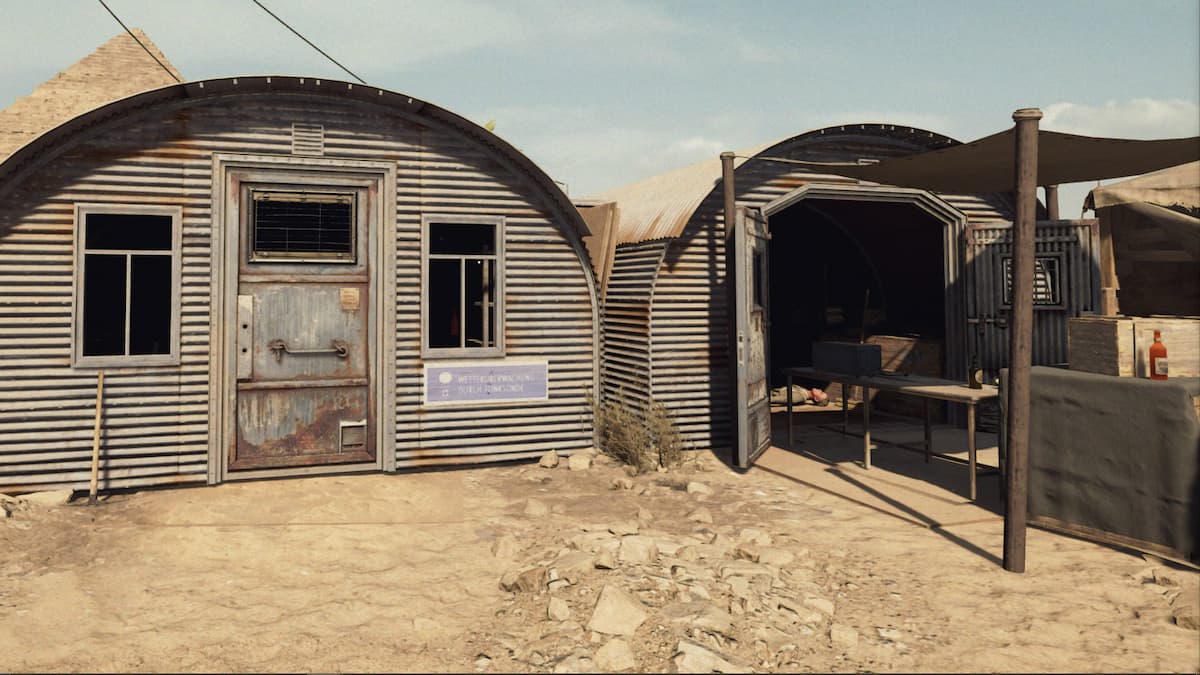 Two small metal structures standing in a desert.