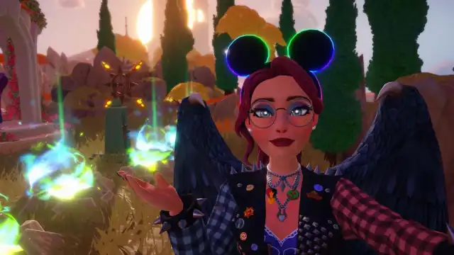 A player wearing black Mickey ears with a rainbow outline holding their hand out to point at some blue and green magical flame spots on the ground in Disney Dreamlight Valley.