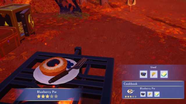 A small circular blueberry pie sitting on a white plate next to a fork on a cooking station in Disney Dreamlight Valley.