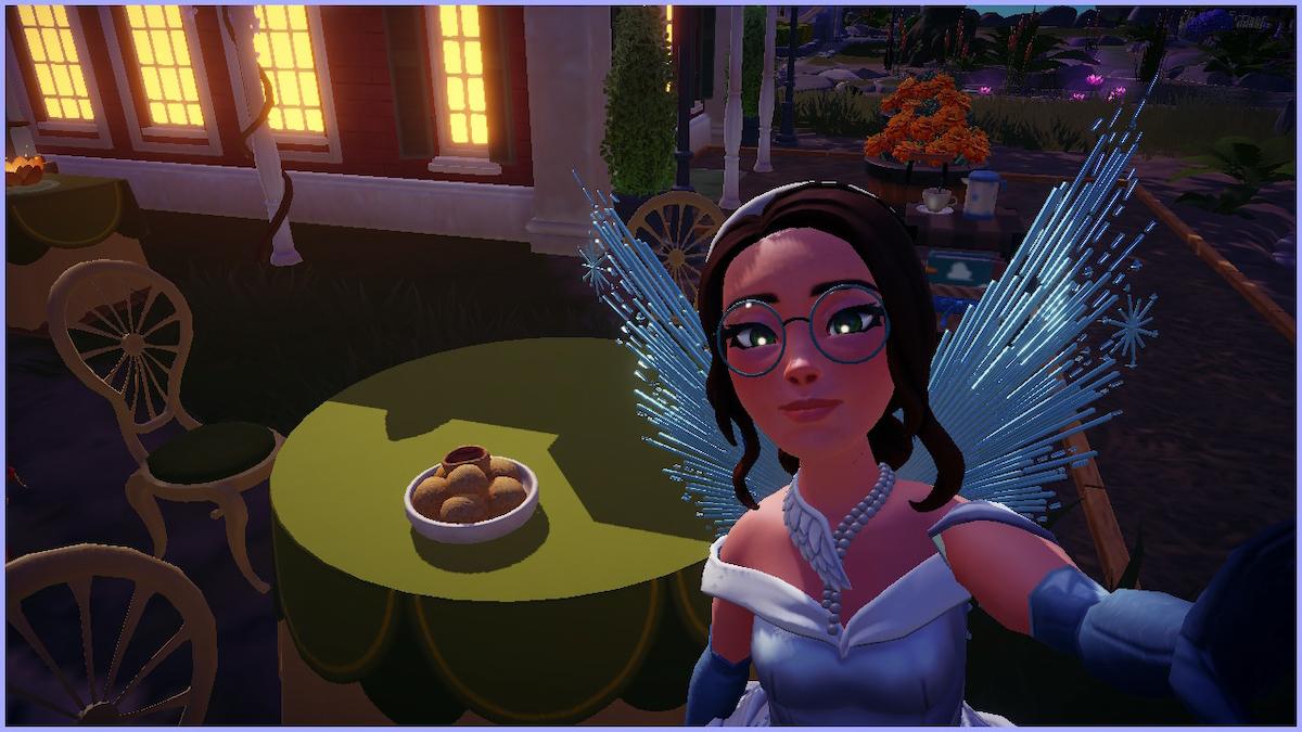 An avatar in Disney Dreamlight Valley taking a selfie with a plate of Sesame Balls on a table with a green cloth.