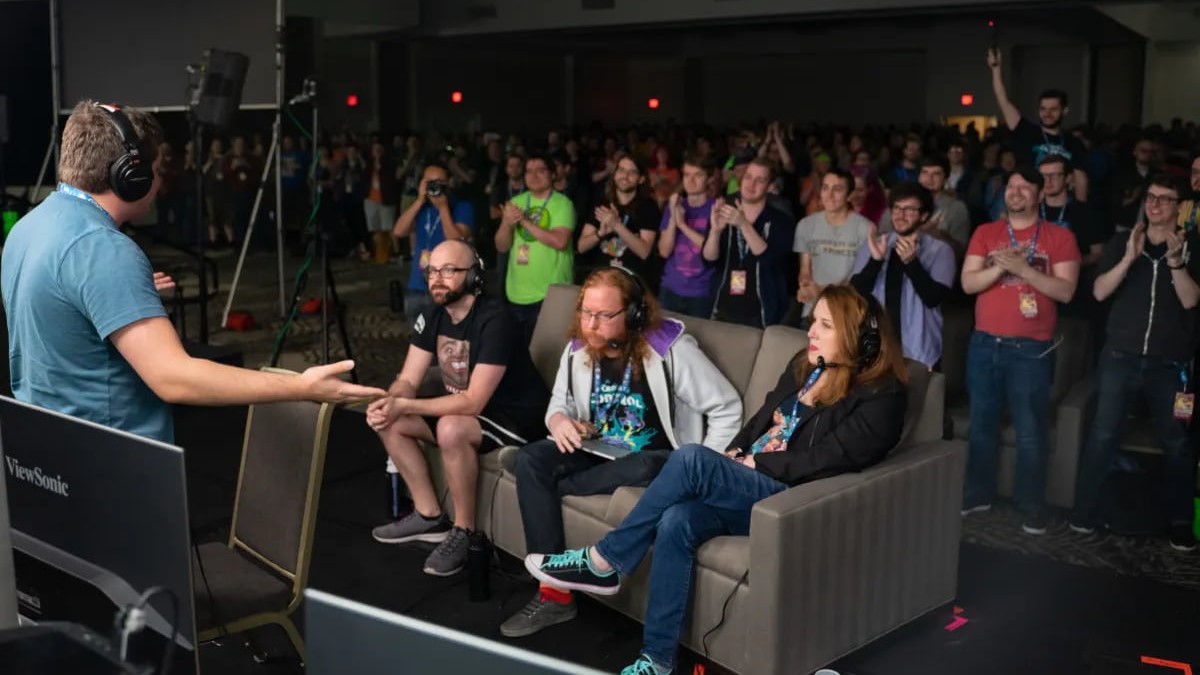 People sitting on a sofa playing a game