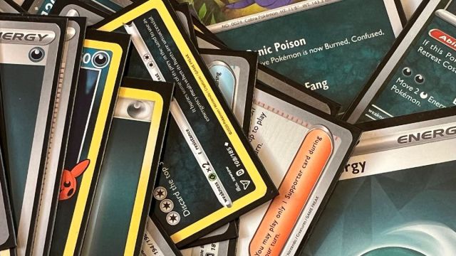 Pokémon cards laid out and zoomed in up close on white cloth.