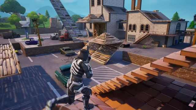 A player wearing a skeleton skin running on a build while reloading their gun in Fortnite OG.