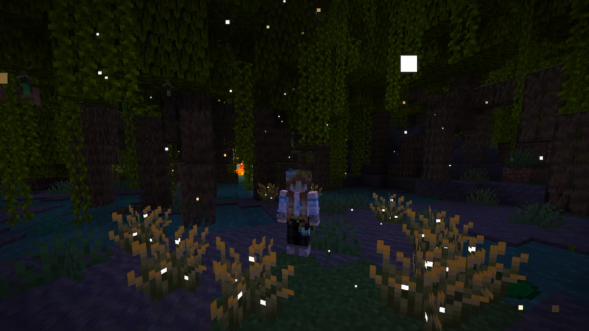 A player standing in a mangrove swamp with fireflies flying all around them at night in Minecraft.