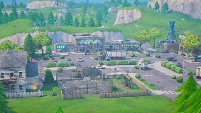 Some retail shops, a parking lot, and a house at Retail Row in Fortnite.