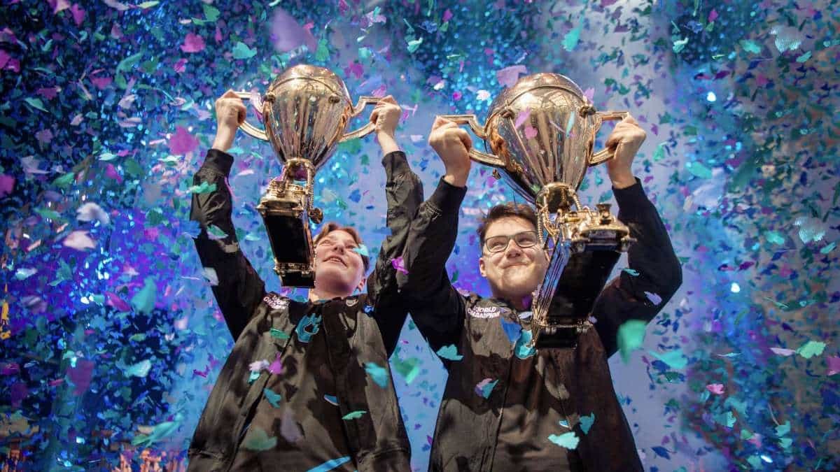 Two players lift of championship trophies as confetti rains down