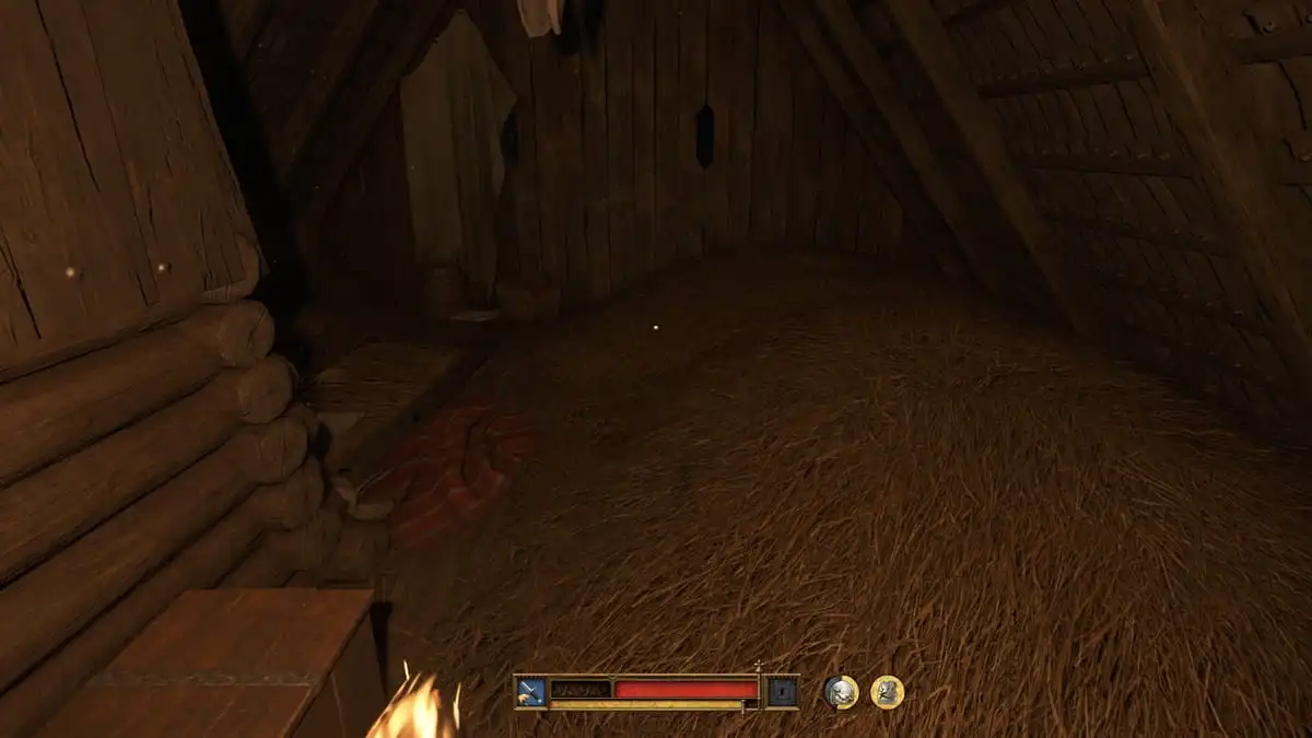 A dark wooden room with a haystack being lit up by a torch in Kingdom Come Deliverance 2