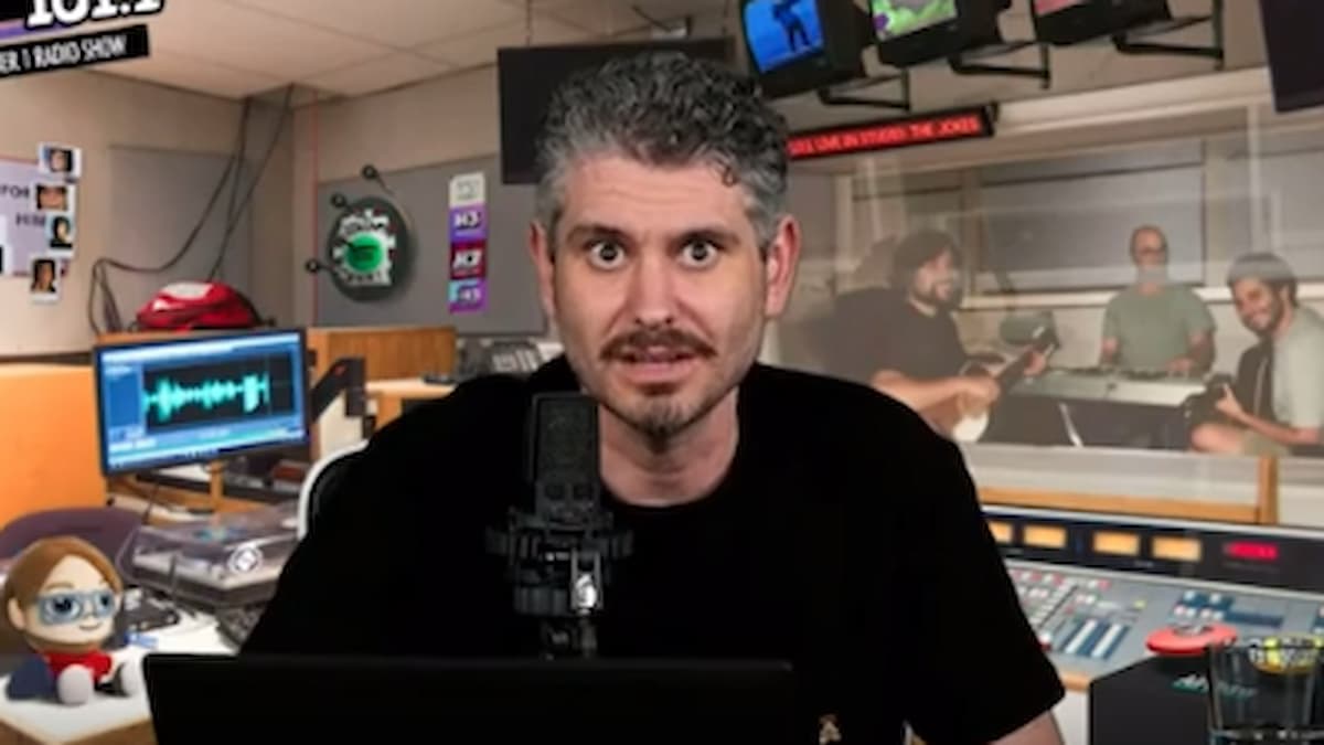 Ethan Klein during a podcast speaking into the microphone with gaming items in his background.